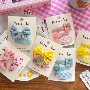 Detailed view of handmade children hair clips with cherry embroidery and plaid bows
