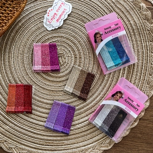 Close-up of colorful glitter bobby pins set in organized packaging for girls