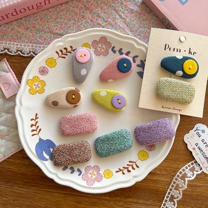 Cute Korean style fabric hair clips with plaid patterns and buttons on a display plate