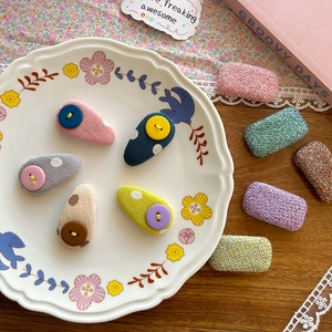 Sweet fabric BB hair clips with plaid and polka dots patterns on a ceramic plate