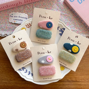 Close-up of fabric button hair clip sets with polka dot patterns on a display tray
