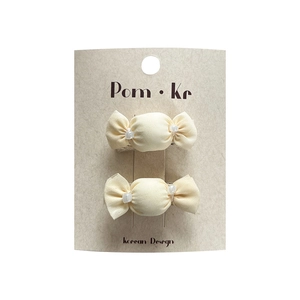 Pair of cream fabric candy hair clips with clear beads on a branded Korean display card