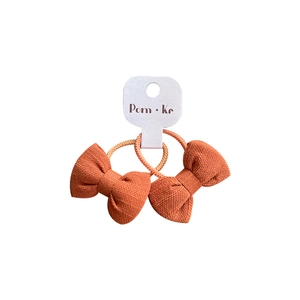 Lot de deux chouchous nœuds en tissu orange avec bandes élastiques sur carte