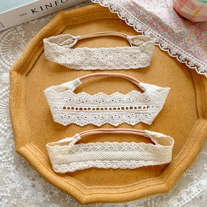 Detailed close-up of three lace baby headbands featuring intricate floral embroidery