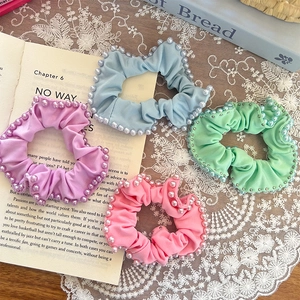 Set of four pastel scrunchies with faux pearls on lace cloth and vintage book