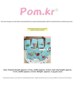 Detailed view of glitter strawberry and cherry hair clips on a card display