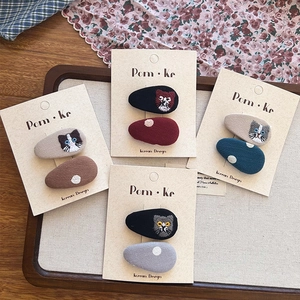 Détails de broderie de chat et pois sur des pinces à cheveux recouvertes de tissu