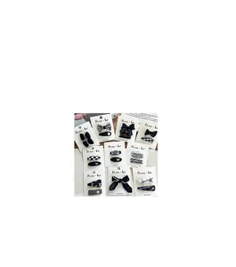 Detail view of black and white bow hair clips with checkered pattern and pearl accents
