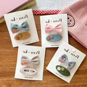 Detail of handmade fabric bow hair clips with cherry embroidery and 3D floral accents