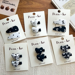 Polka dot and floral heart fabric hair clips set displayed on a wooden surface