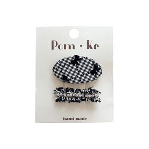 Chic black and white houndstooth hair clips set with pearls and bows on a display card