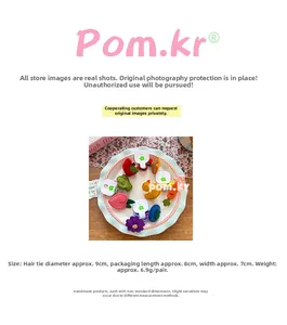 Dettaglio di elastici per capelli per bambini con ricami di frutta e fiori