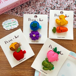 Vue détaillée de barrettes en feutre fait main avec canards et motifs de fruits