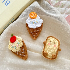 Detail of crochet ice cream and toast hair clips with knit textures and cute fruit designs