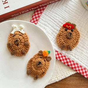 Detailed view of handmade crochet capybara hair clips with cute hats and ears