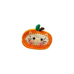 Handmade crochet pumpkin hair clip featuring a cute cat design for kids and Halloween style