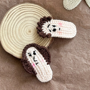 Barrettes à cheveux en tricot faites main avec visages de dessins animés sur fond bois