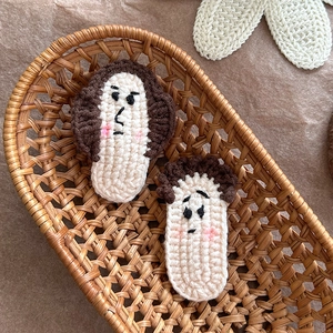 Détail de barrettes à cheveux en crochet fait main avec visages rigolos dans un panier