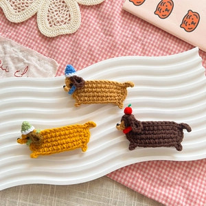 Handmade crochet dachshund hair clips in three colors on a white decorative tray