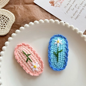 Barrettes à cheveux marguerites crochetées à la main en rose et bleu sur plat