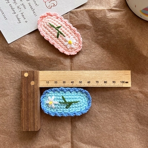 Barrettes à cheveux marguerites crochetées à la main en rose et bleu sur fond brun