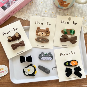 Barrettes à cheveux faites main motif ours et pingouin sur plateau d'exposition