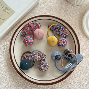 Ensemble de chouchous à fleurs et barrettes à cheveux dans une assiette en céramique
