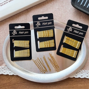 Golden metal hair pin set with straight and wavy designs on black card packaging