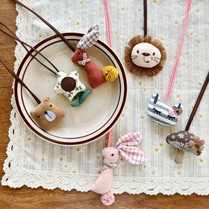 Cute Korean cartoon stuffed bear and animal charms for kids on a vintage lace table
