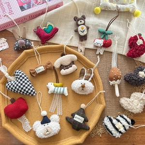 Cute handmade bear and heart plush pendants with lace ribbon on a yellow tray