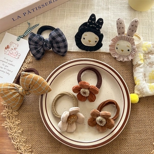 Detailed shot of Korean style velvet flower and plaid bow hair ties with cute bunny motifs