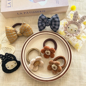 Detail of floral velvet and plaid bow hair ties with cute embroidered bunny designs
