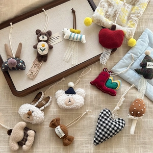 Variety of handmade fabric charms including bears and rabbits on a rustic wooden tray