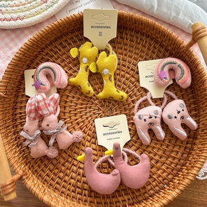 Detailed set of cute plush animal hair ties including giraffe and bear on card