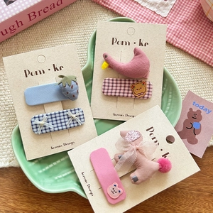 Set of six Korean cartoon fabric hair clips including strawberry and bow designs on a tray