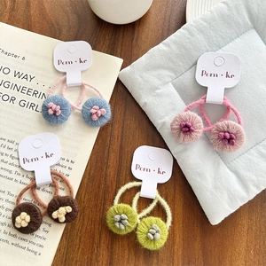 Élastiques à cheveux fleurs tricotés en bleu, rose, marron et vert sur carte blanche
