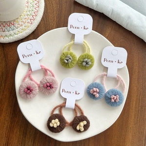 Détail de quatre paires d'élastiques à cheveux fleurs tricotés main en plusieurs couleurs