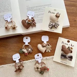 Detailopname van handgemaakte vilten haaraccessoires met bloemen en beren in bruin