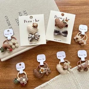 Detailweergave van handgemaakte bruine haarspelden met strikken, bloemen en hartjes voor kids