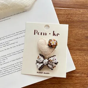 Detail van handgemaakte haaraccessoires met hart, bloemvilt en strik op kaart
