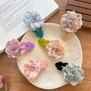 Detail of floral fabric hair clips with sparkling center diamonds in pastel colors