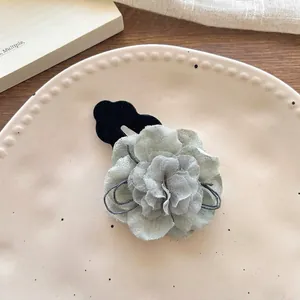 Detail of Korean fabric flower hair clip with light green layers and soft velvet base