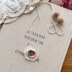 Detail of handmade lace flower embroidery headband with vintage tassels and crochet work