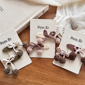 Lot de 3 barrettes à cheveux avec nœuds tricotés et pompons en vert, rose et marron