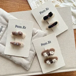 Détail de barrettes à nœuds en dentelle et fleurs avec perles sur carte de support