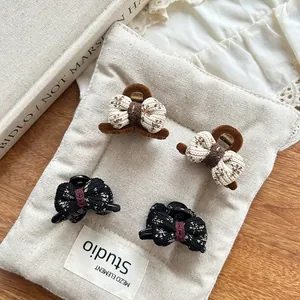 Détail de mini pinces à cheveux avec nœud en tricot et texture velours sur tissu