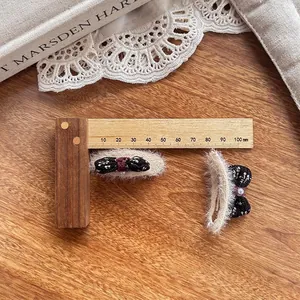 Détail de pinces à cheveux en peluche avec nœuds jacquard et perles sur bois