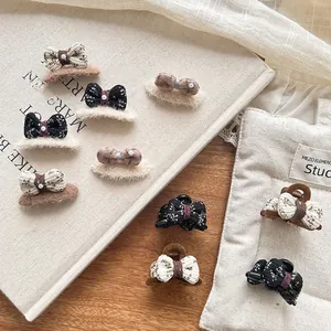 Détail de l'ensemble de barrettes nœuds tricotés avec perles sur un livre d'art