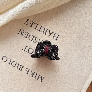 Vue détaillée d'une pince à cheveux à nœud floral sur une page de livre et du lin