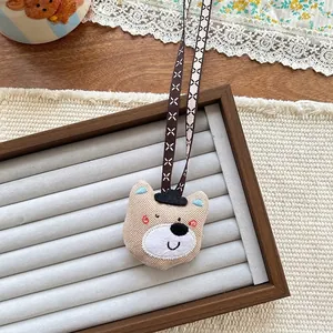 Detailed view of a handmade brown stuffed bear pendant with a cute black top hat accessory